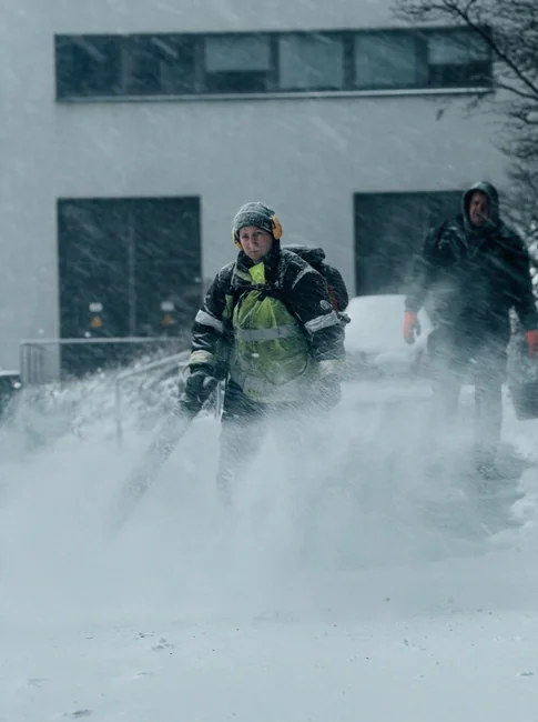 Crop faceless male in orange rubber gloves wiping by sponge shower nozzle